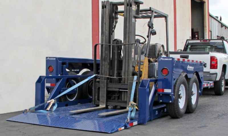 Forklift loaded at ground level and strapped down to D-rings